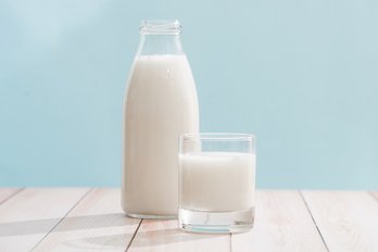 Milchflasche und Milchglas auf Holztisch ©makistock_stock_adobe_com