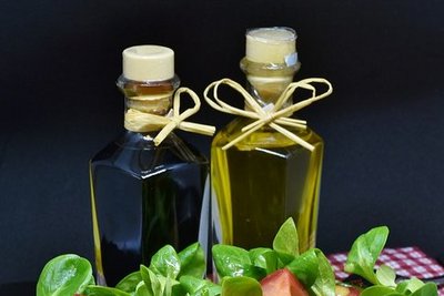 Balsamico-Essig und Öl stehen hinter einem Teller mit Vogerlsalat