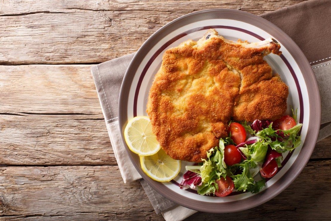 Schnitzel mit Salat und Zitrone auf Teller