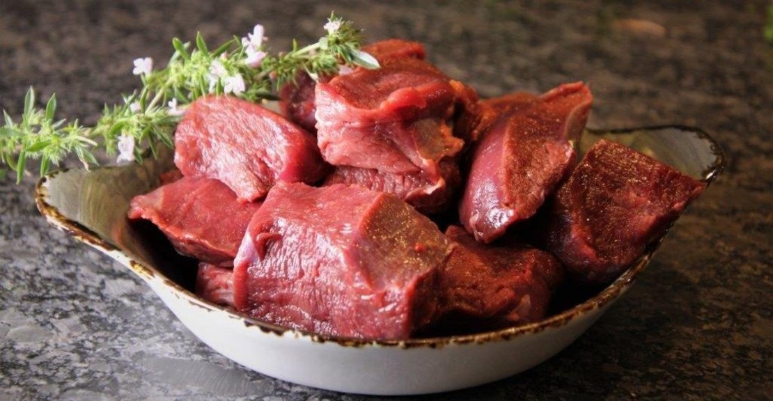 Wildfleisch für Hirschragout roh in einer Schüssel mit Kräutern